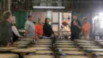 A tour guide takes a group through the Buffalo Trace Barrel Receiving and Inspection area which is full of bourbon barrels.