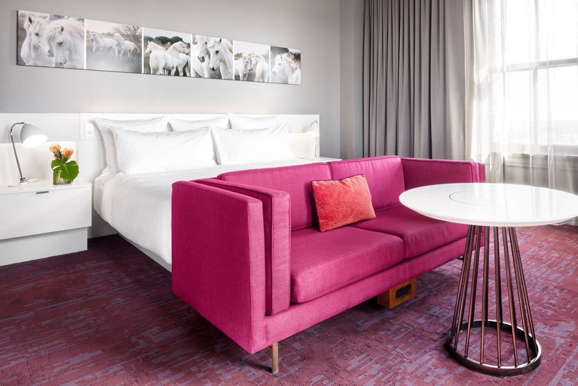 A bed, couch and table in a 21C Museum Hotel Room
